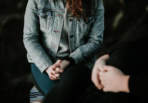 People sitting together with hands in laps.